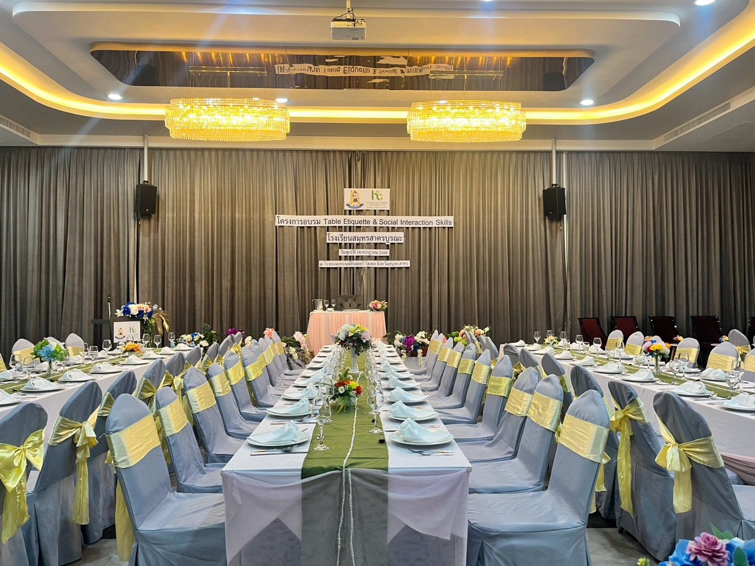 Long banquet tables with green runners facing the stage in Grand Diamond