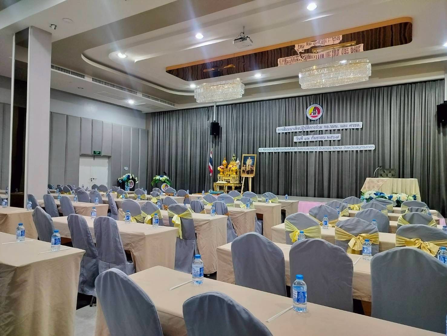 Seminar set-up with a stage backdrop and flowers in Grand Diamond