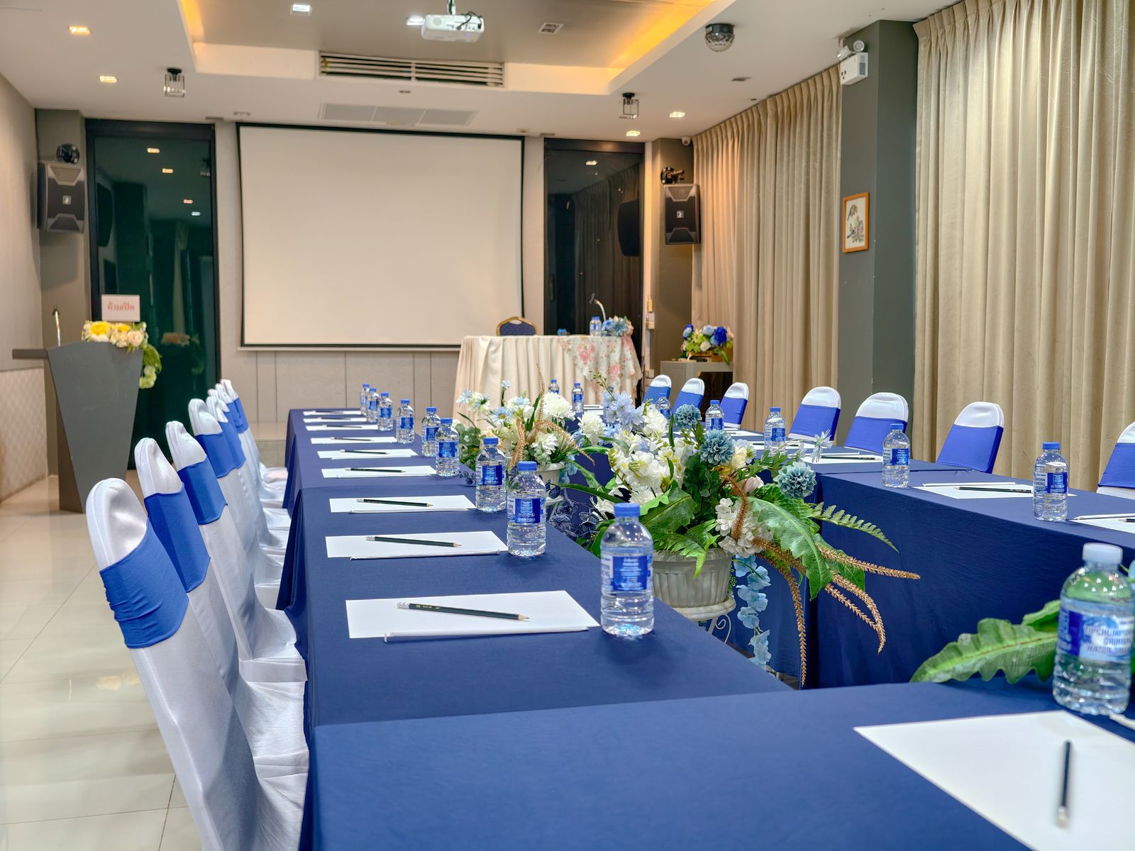Meeting table laid with notepads, pens and drinking water