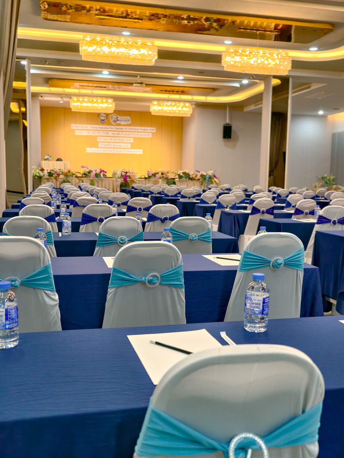 Close-up of seminar tables with notepads and water at every seat