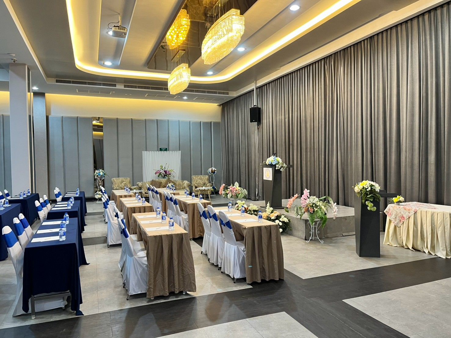 Grand Diamond set for a seminar with long tables, flowers and a lectern