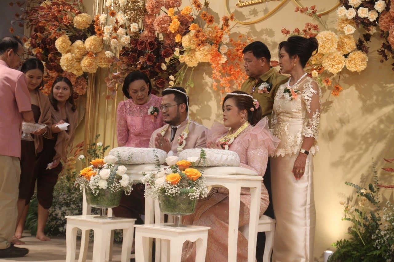 Families gathered on stage for a Thai wedding ceremony