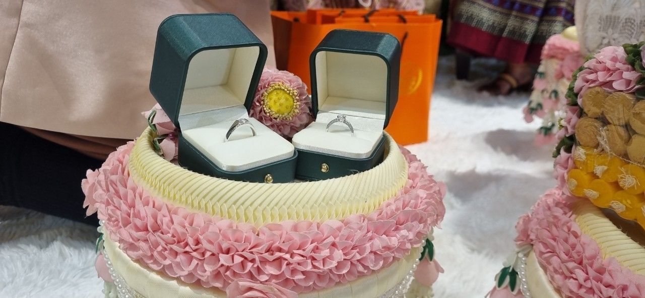 Wedding rings presented on a traditional Thai offering tray