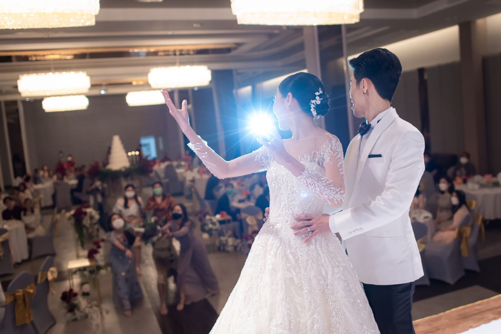 Bride and groom celebrating on stage with guests in the ballroom