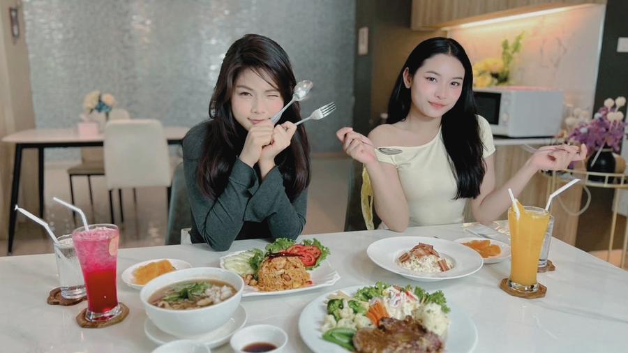 Two guests enjoying Thai and Western dishes with fresh drinks