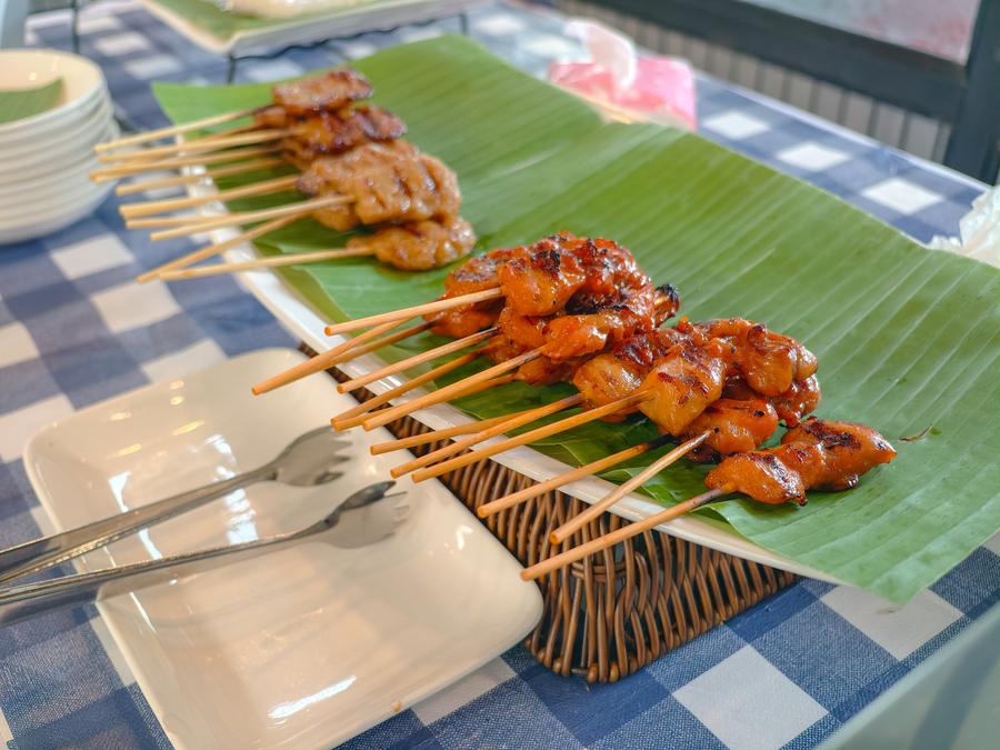 Grilled pork skewers served on banana leaf