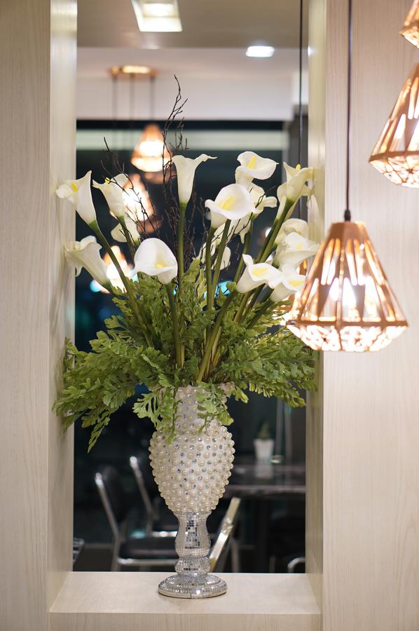 Calla lilies arranged beside copper pendant lights