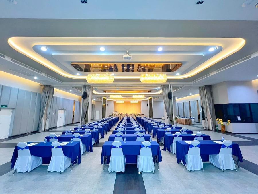 Grand Norasing ballroom with blue seminar tables, seen from the back
