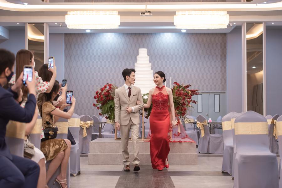 Couple in traditional dress walking past guests in the ballroom