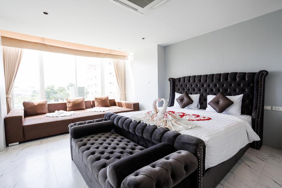 Honeymoon Suite with a tufted bed, lounge sofas and wide windows