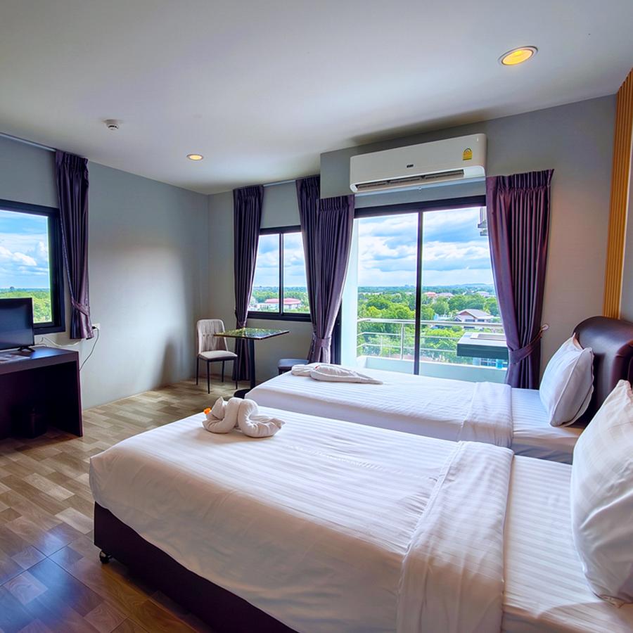 Twin room with white beds and a balcony overlooking green countryside