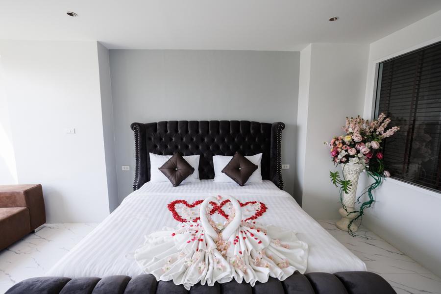Bed decorated with towel swans and rose petals