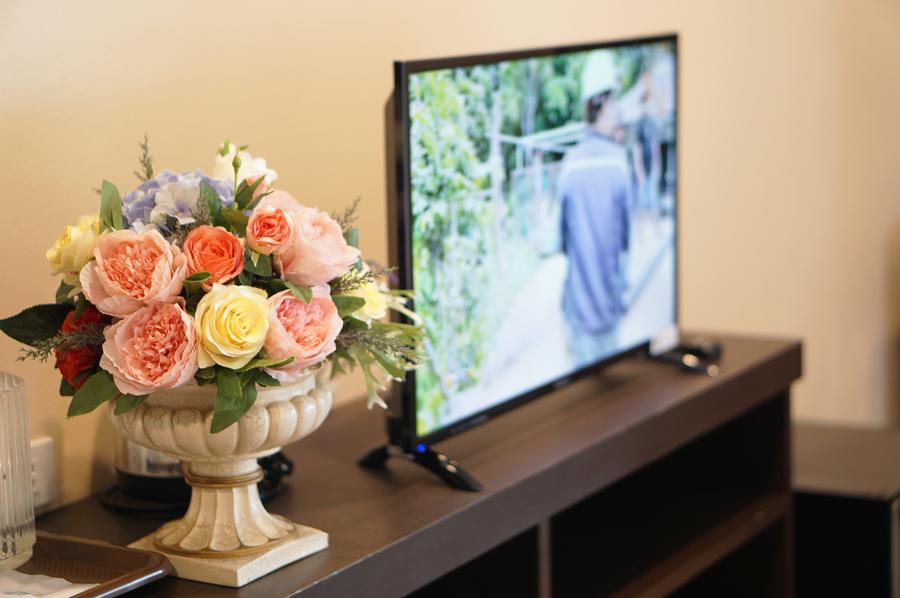 Fresh flowers beside the TV in a guest room