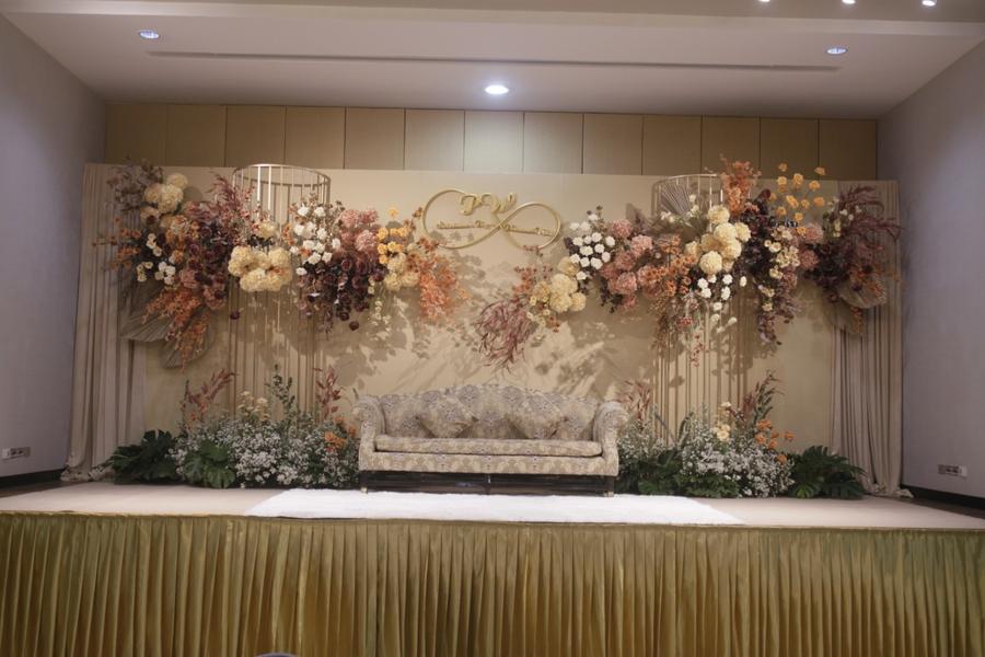 Floral wedding backdrop in autumn tones with a sofa for the couple