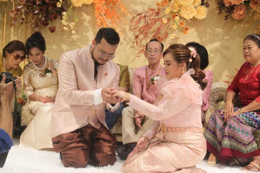 Couple kneeling before their families during the ring ceremony
