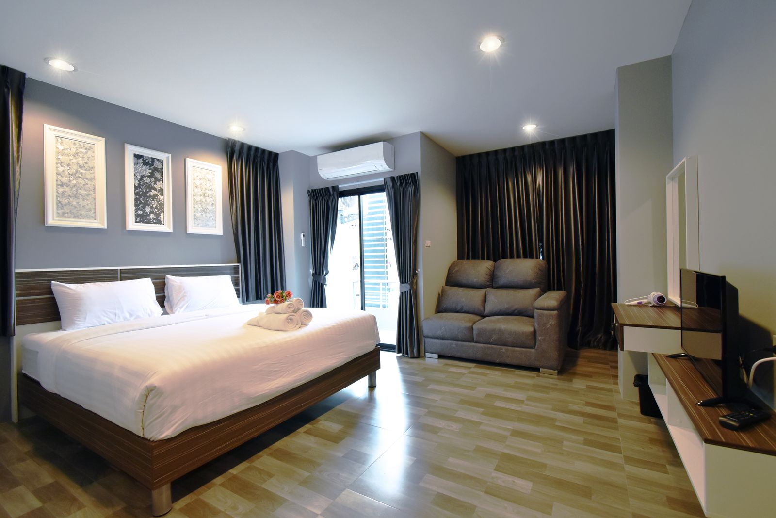 Deluxe room with a double bed, sofa and dressing table