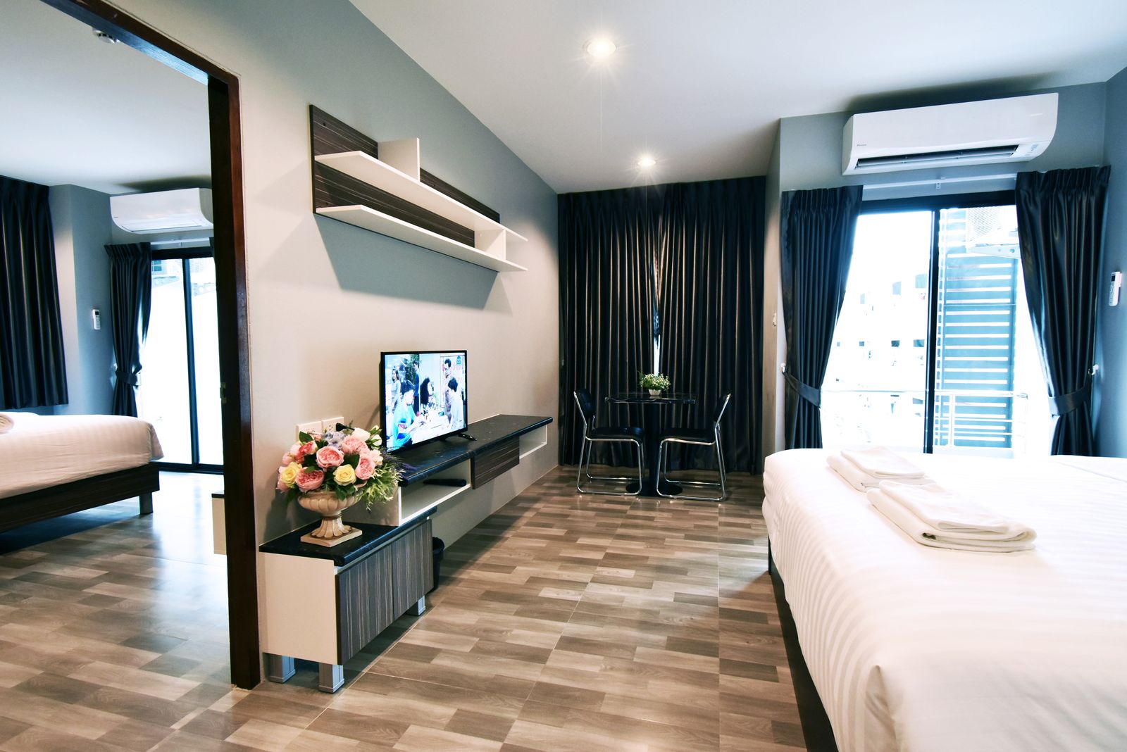 Executive room bedroom with TV unit and living area beyond