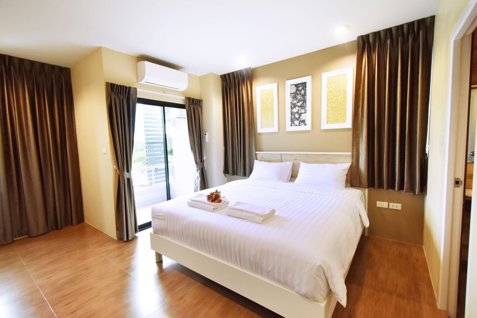 Double bed with balcony doors and framed artwork