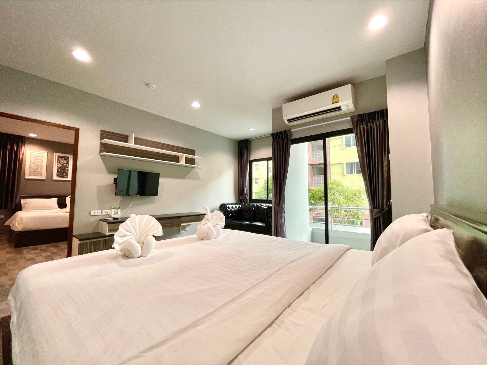 Bed with towel swans and a living area with sofa