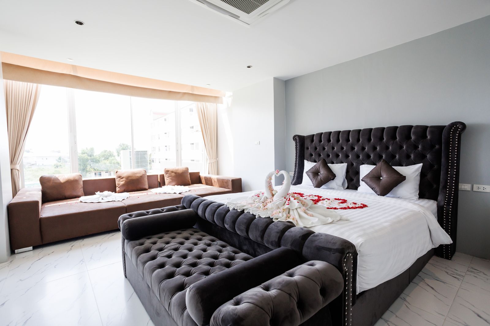 Honeymoon Suite with a tufted bed, lounge sofas and wide windows