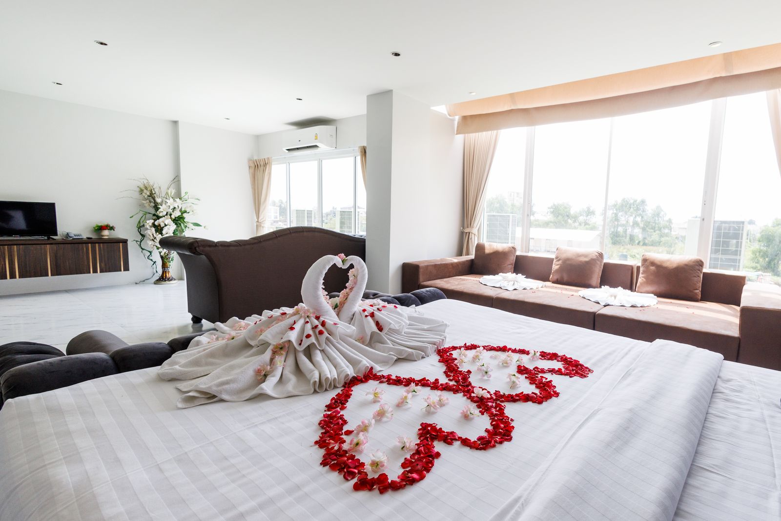 Bed with rose-petal hearts and lounge sofa