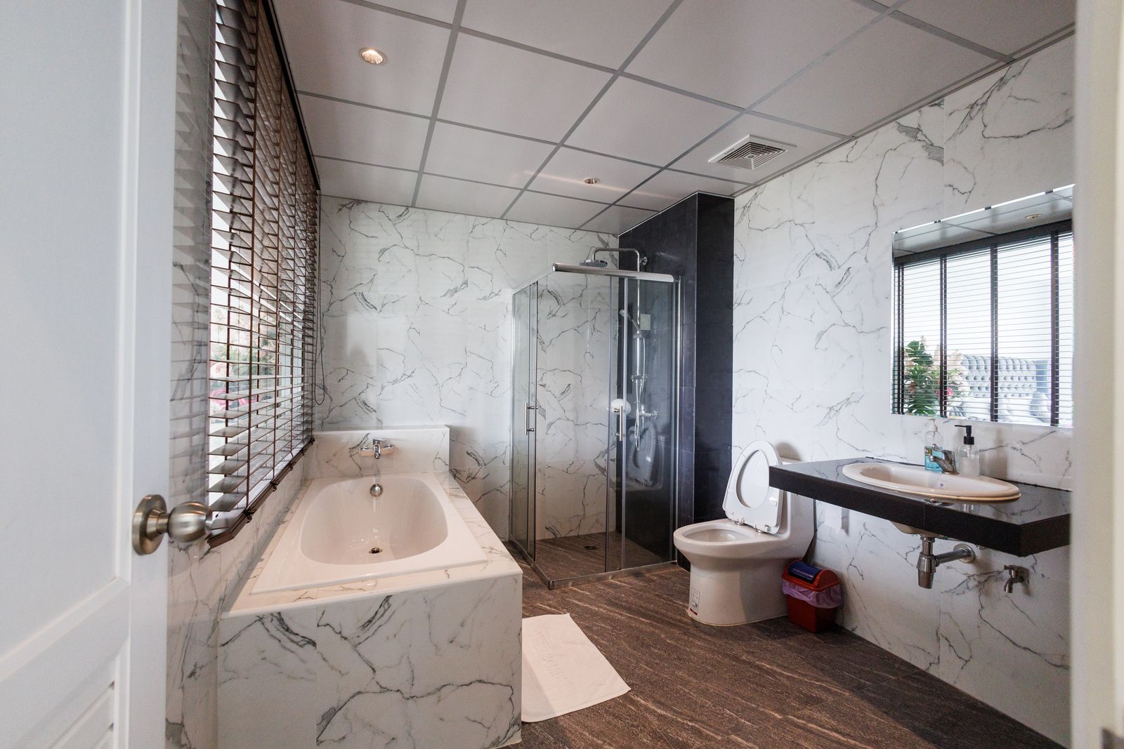 Marble bathroom with bathtub and glass shower
